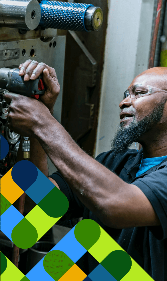 A man working on large machinery with abstract blue and green shapes overlaying.